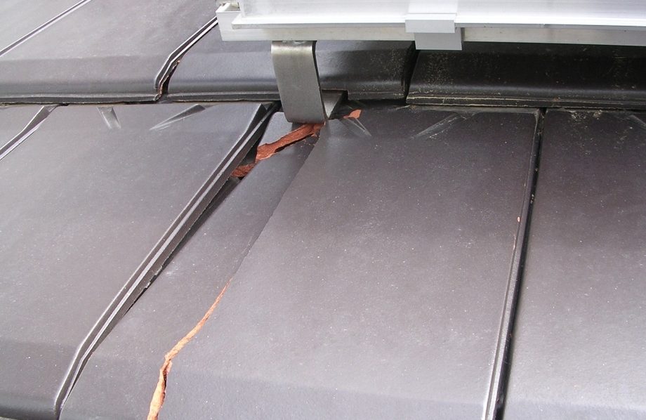 Pęknięta dachówka pod źle zamontowanym hakiem dachowym instalacji PV